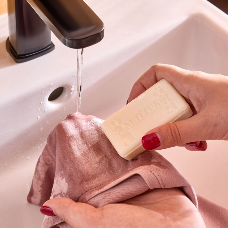 De zeep over de vlek wrijven