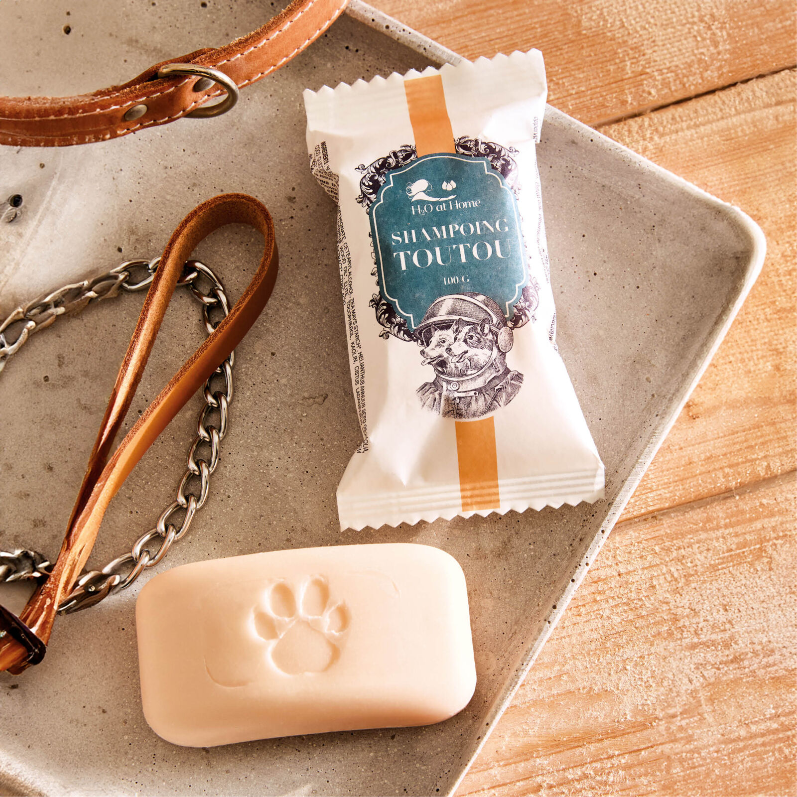 Savon solide pour la vaisselle emballé dans un sachet blanc avec une étiquette verte, illustré avec des ustensiles de cuisine et le texte 'Savon Vaisselle Dish Soap Bar&quot;