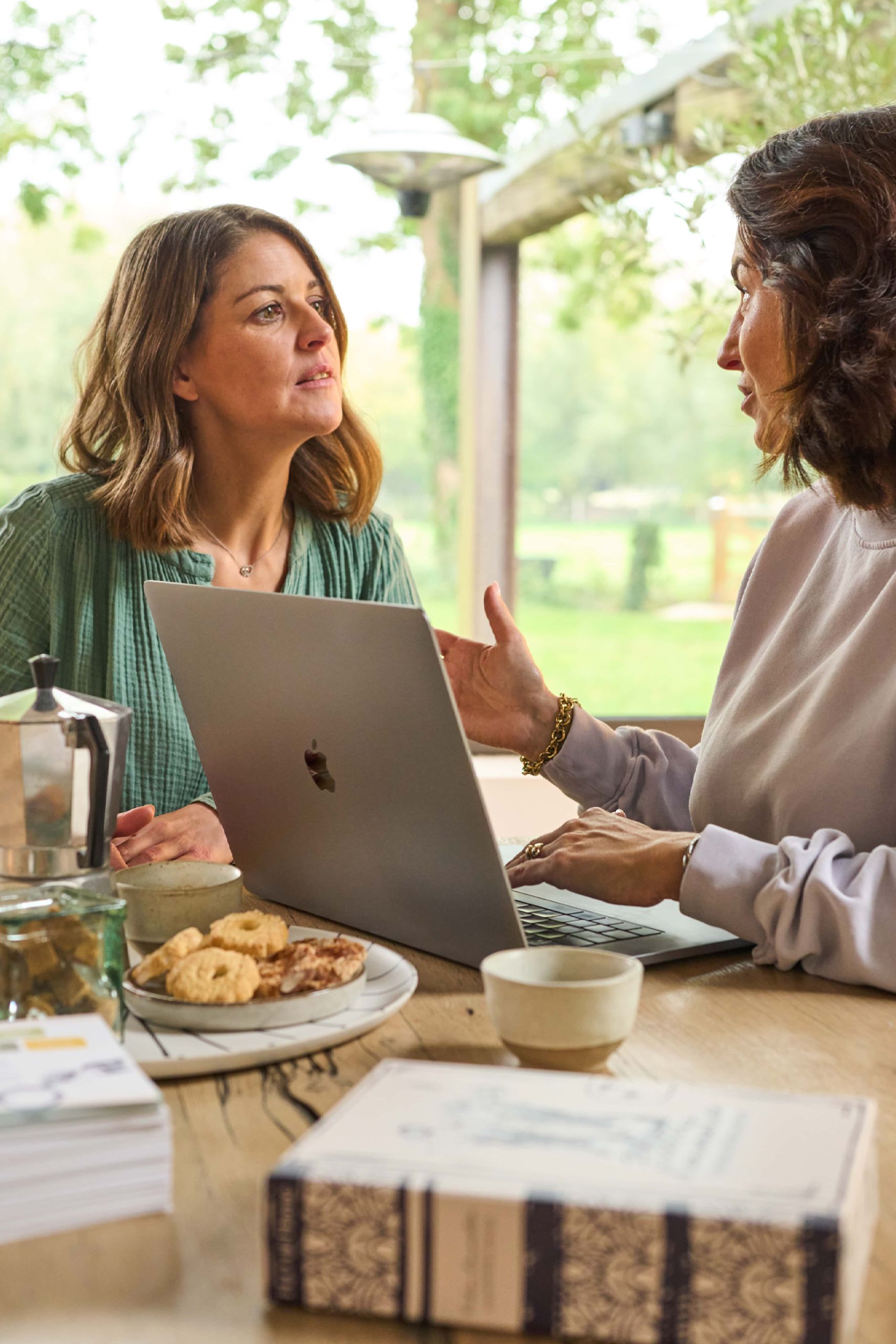 Deux conseillères discutent avec un ordinateur, remplir document