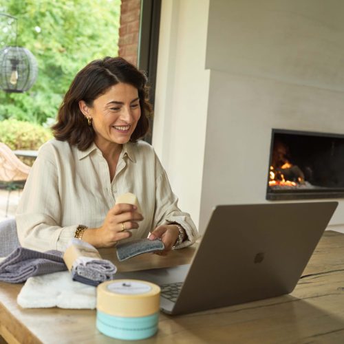 Photo d'un atelier digital H2O at Home réalisé à distance depuis un ordinateur, avec une conseillère montrant l'utilisation de l'éponge avec le solide vaisselle H2O at Home devant sa caméra