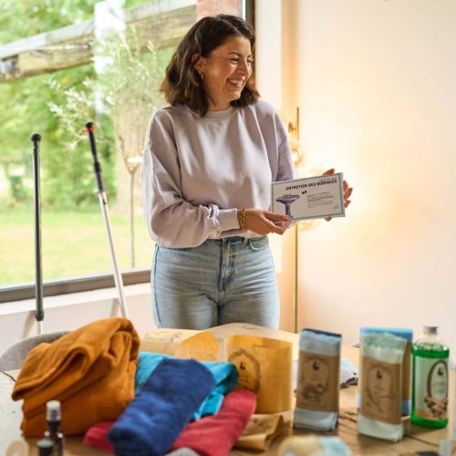 Photo d'un atelier H2O at Home à domicile avec conseillère présentant ses fiches devant des produits salle de bain H2O at Home