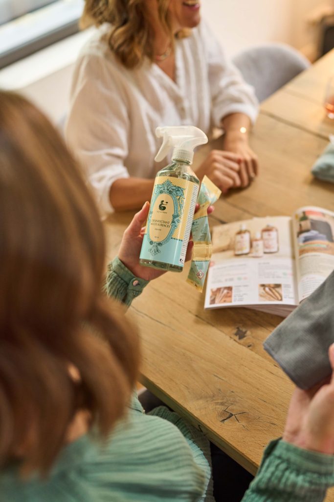 Personne tenant le désinfectant multi-surfaces H2O at Home dans sa main