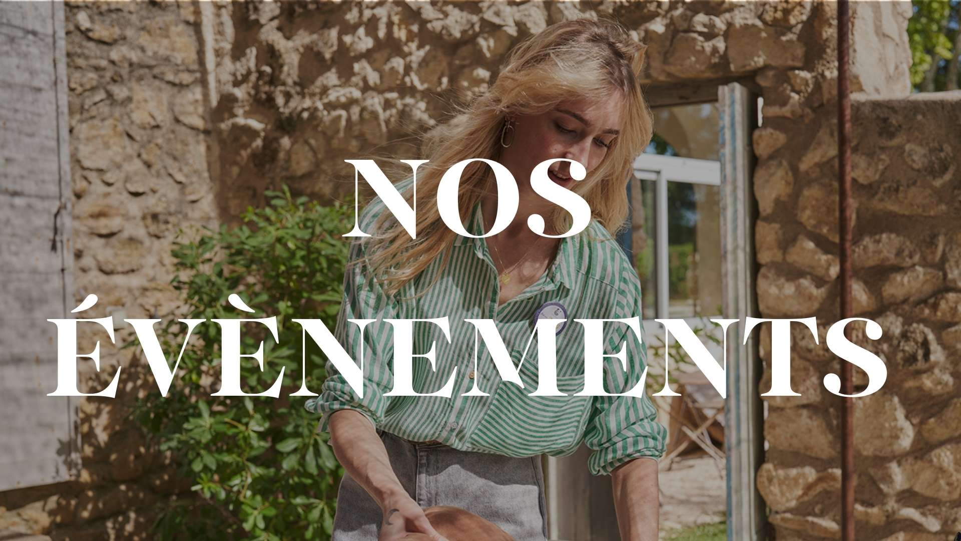 Femme en chemise verte rayée et badge H2O at Home participant à un événement en extérieur devant une maison en pierre, avec l'inscription "NOS ÉVÈNEMENTS" en texte blanc